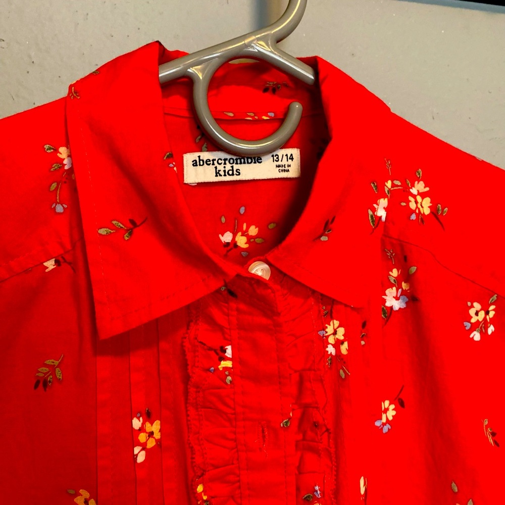 Girls shirt red with ruffle in front, never worn.